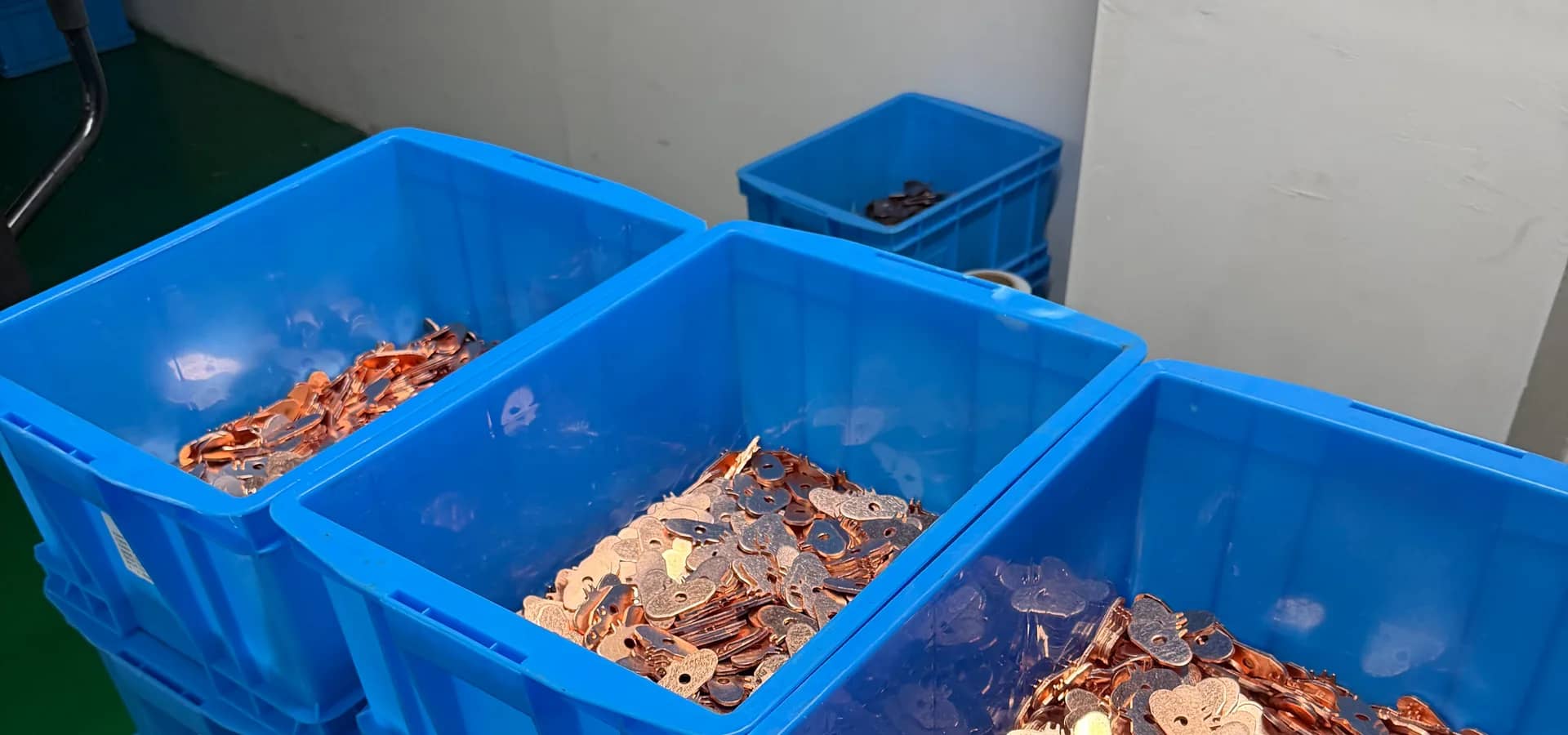 Batch of electrical contact assemblies arranged in production bins.