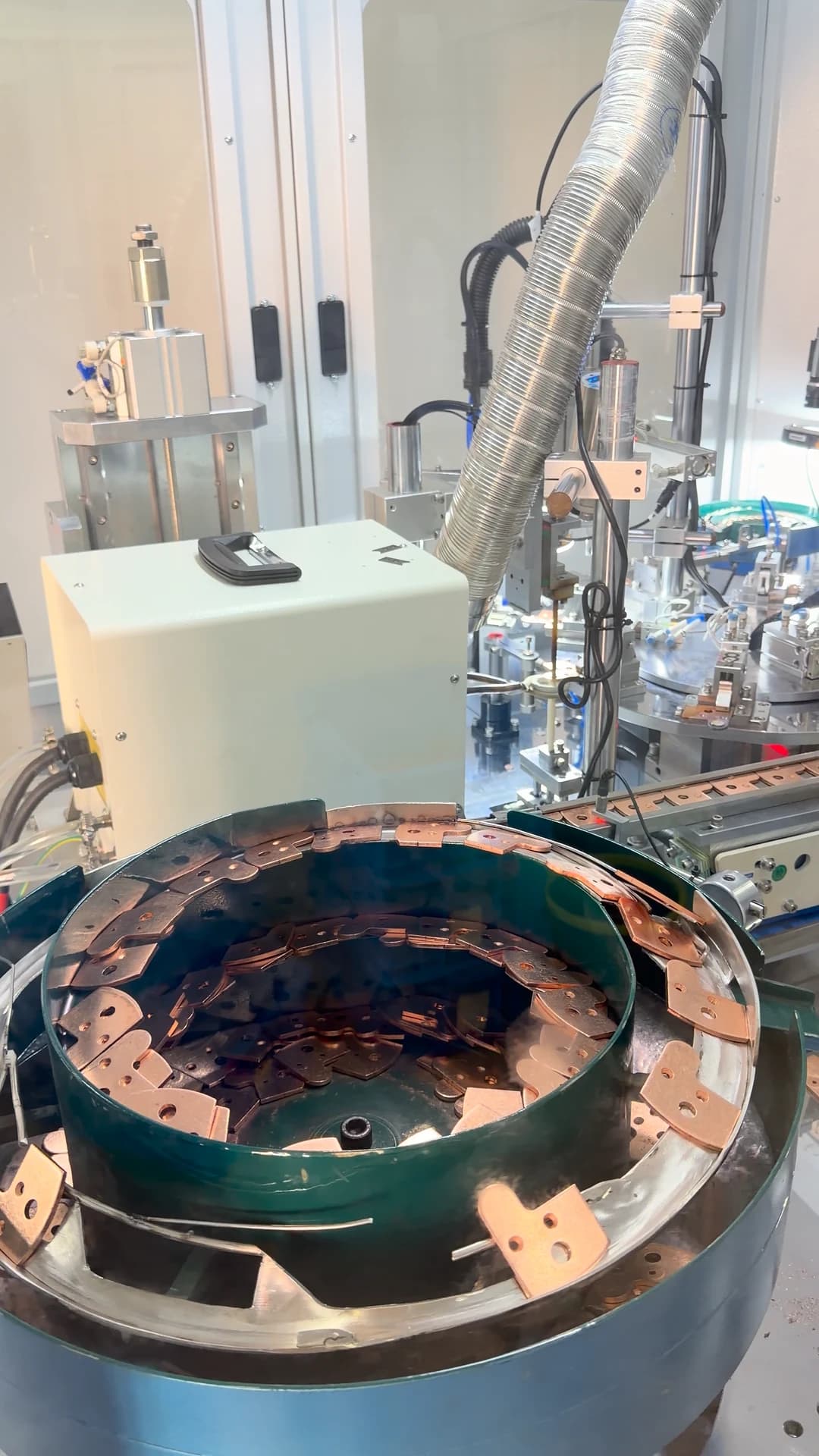 Components moving through a feeding bowl and production station.