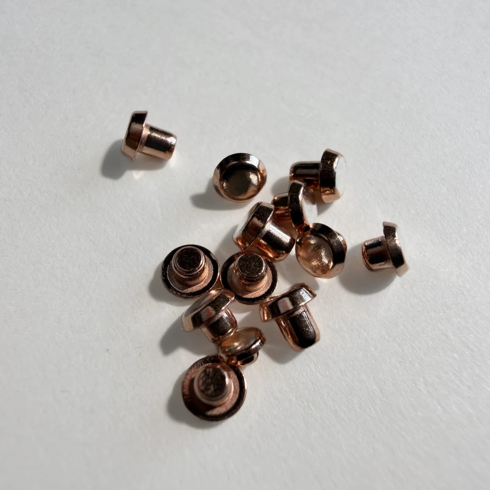 Electrical contact rivets photographed to show part forms; material grade is established from the specification rather than appearance.
