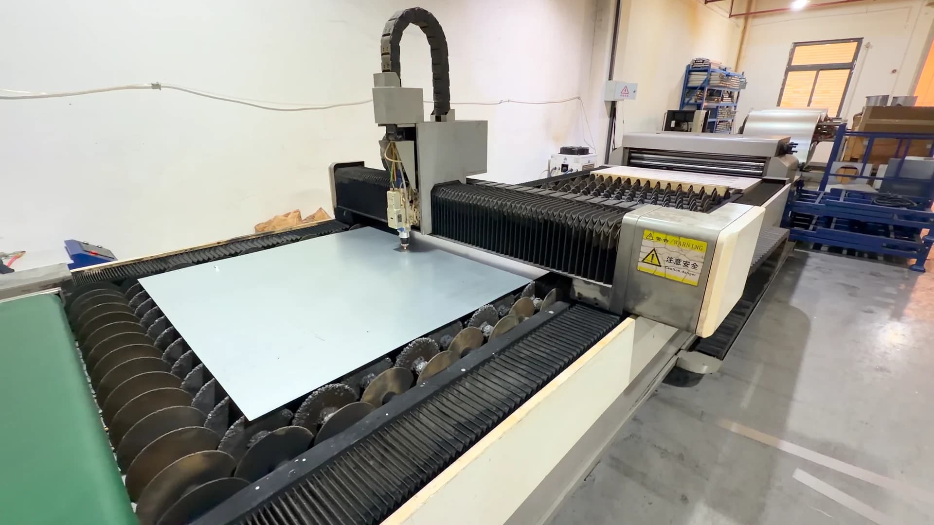Sheet material on a processing table with adjacent racks.