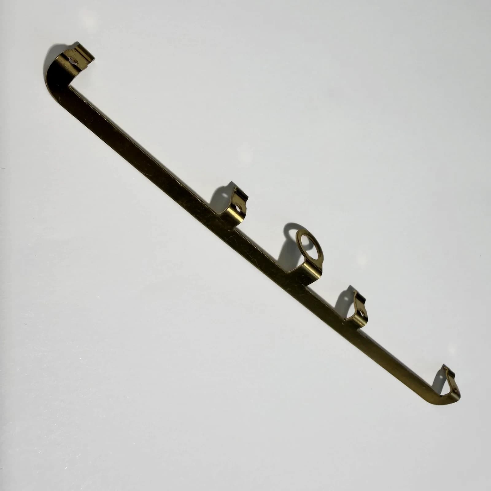 Custom stamped conductive supports and terminals arranged on a light neutral background.